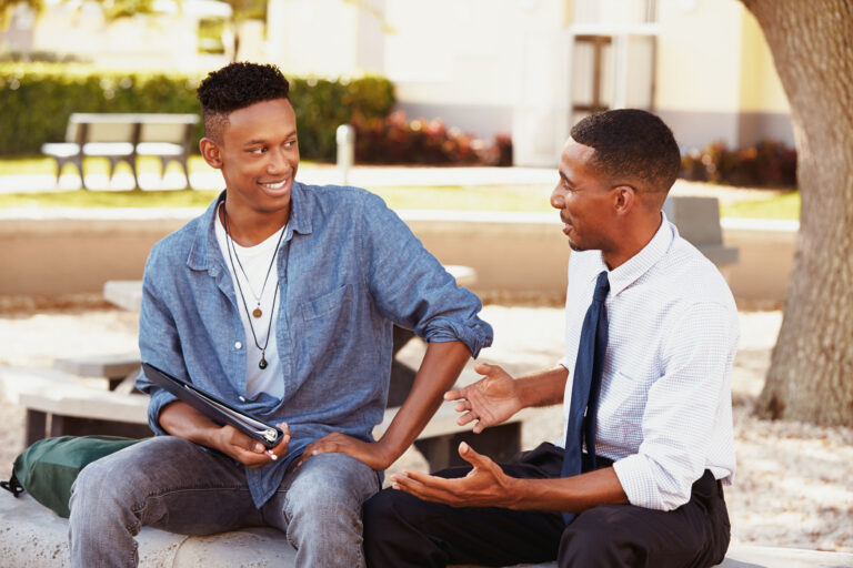 Male teen getting mentored by a teacher